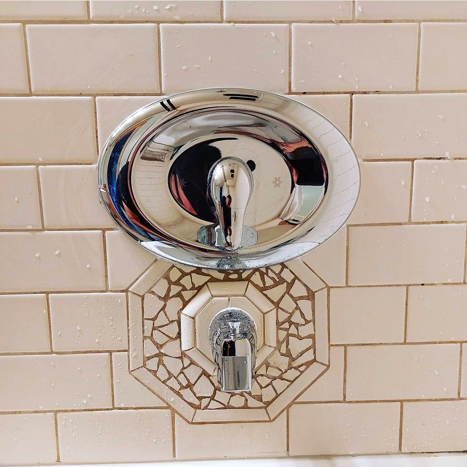 New chrome shower valve and trim on cream subway tile