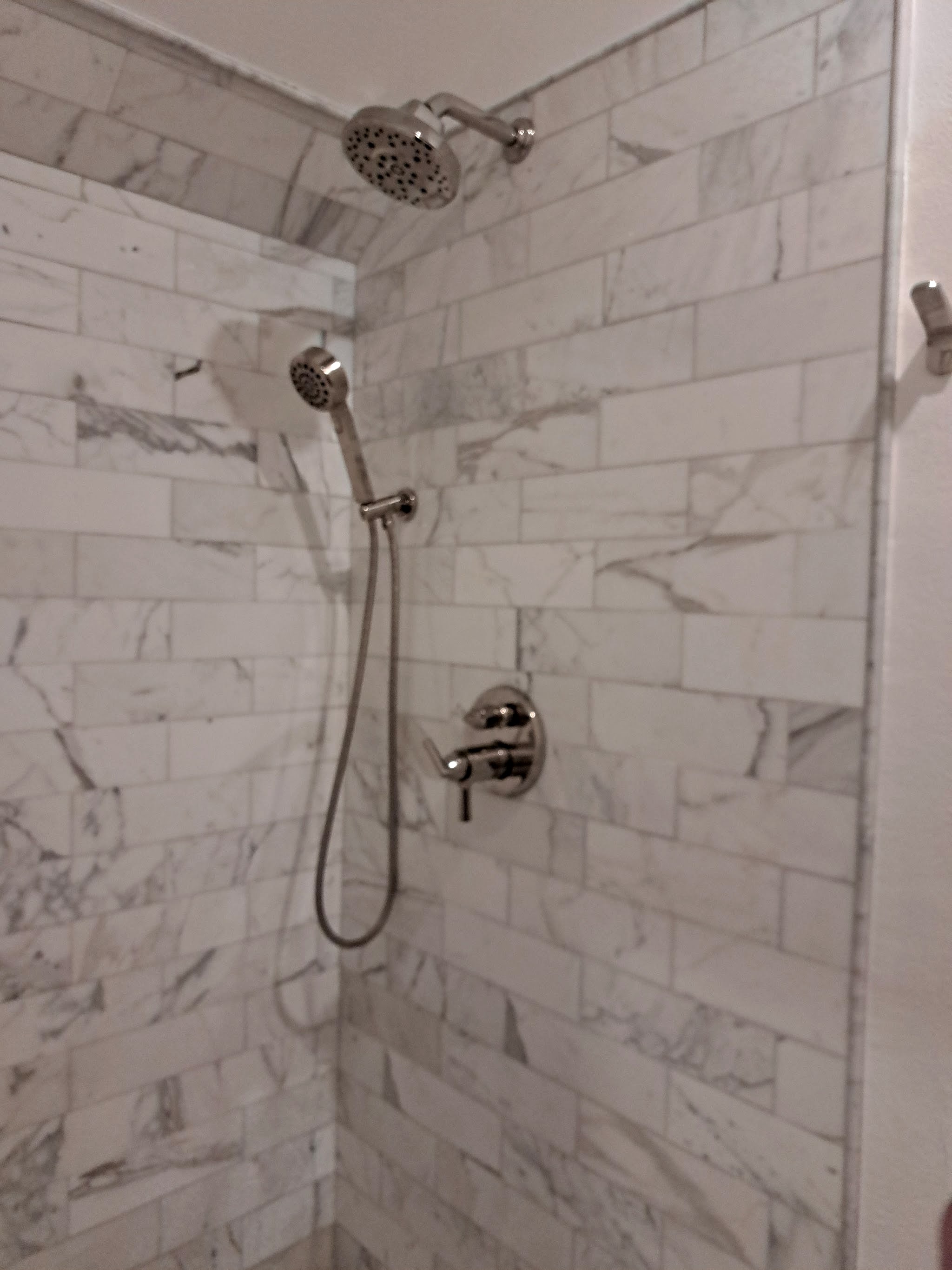 Finished marble-look tiled shower with a rain head, handheld and new valve
